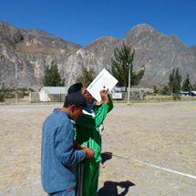 Two students take measurements outdoors.