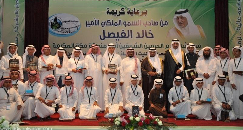 Several people stand and crouch together for a group photo showing their awards.