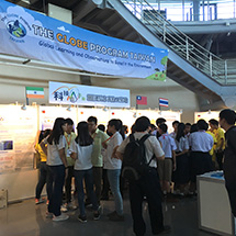 Students present posters to each other in a large hall.