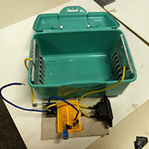 A box with a board and wires.  