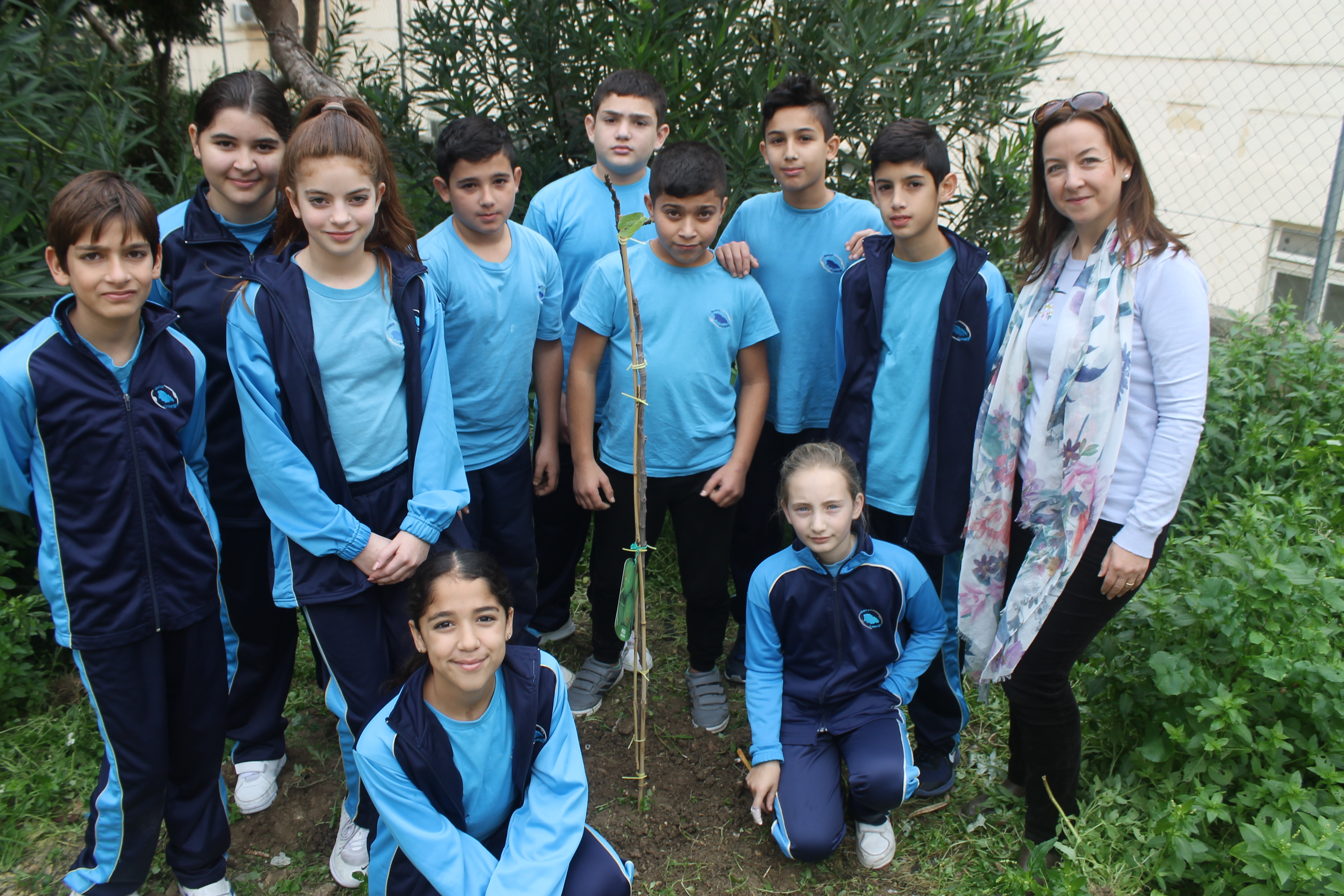  Students from Gozo College Middle School (Victoria, Gozo, Malta), together with their teacher, Ms. Ramona Mercieca, with the newly planted Fig Tree in the school garden.