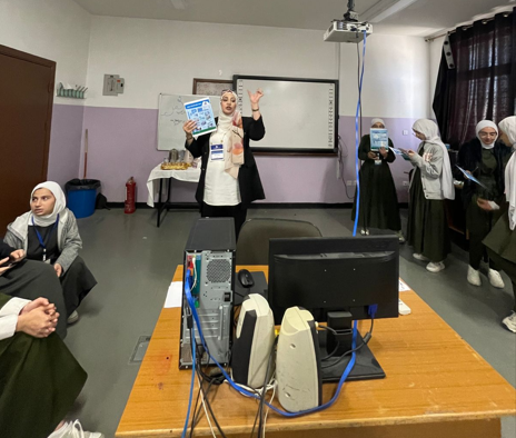 A woman standing in front of a group of adults showing them how to use a GLOBE cloud identification chart.