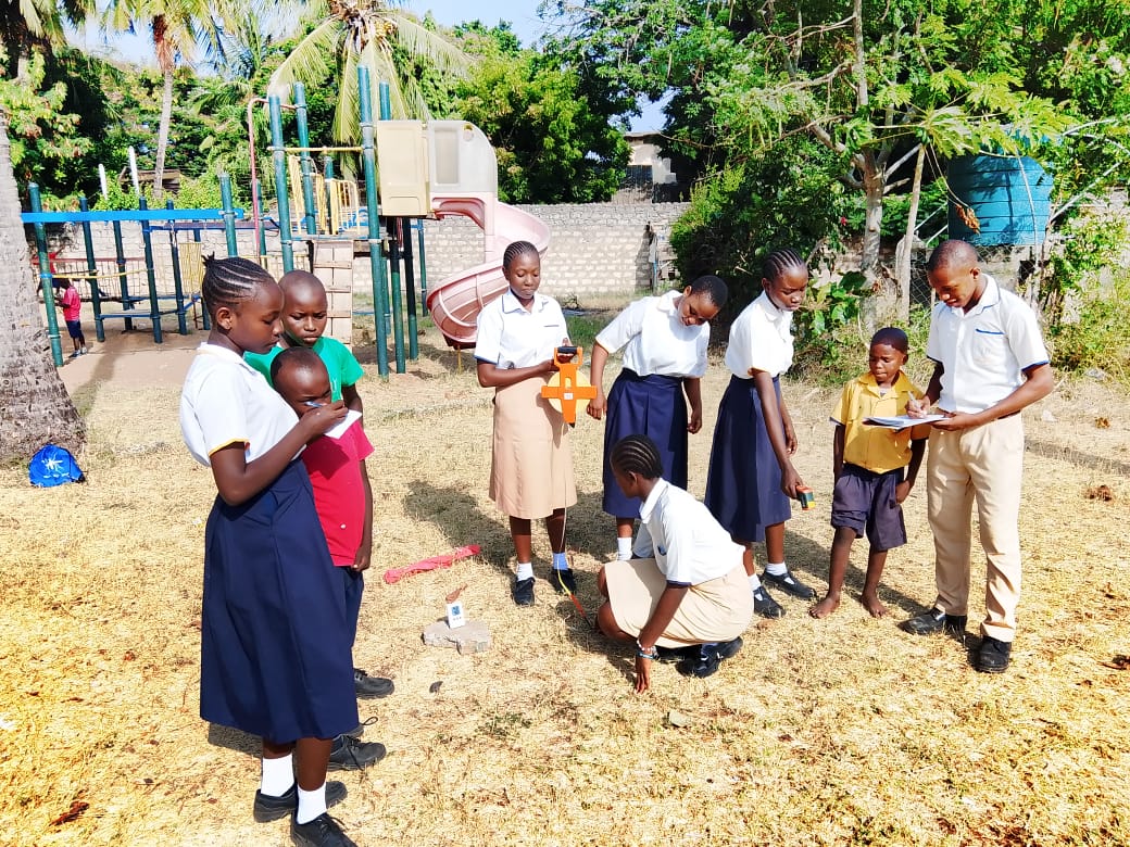 Kids in outdoor playground taking surface temperature measurements.