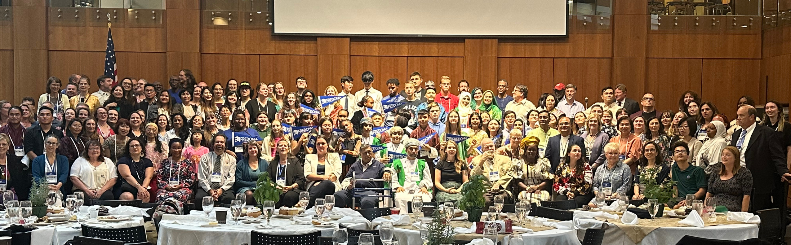 GLOBE Annual Meeting participants sit and stand together during the closing banquet