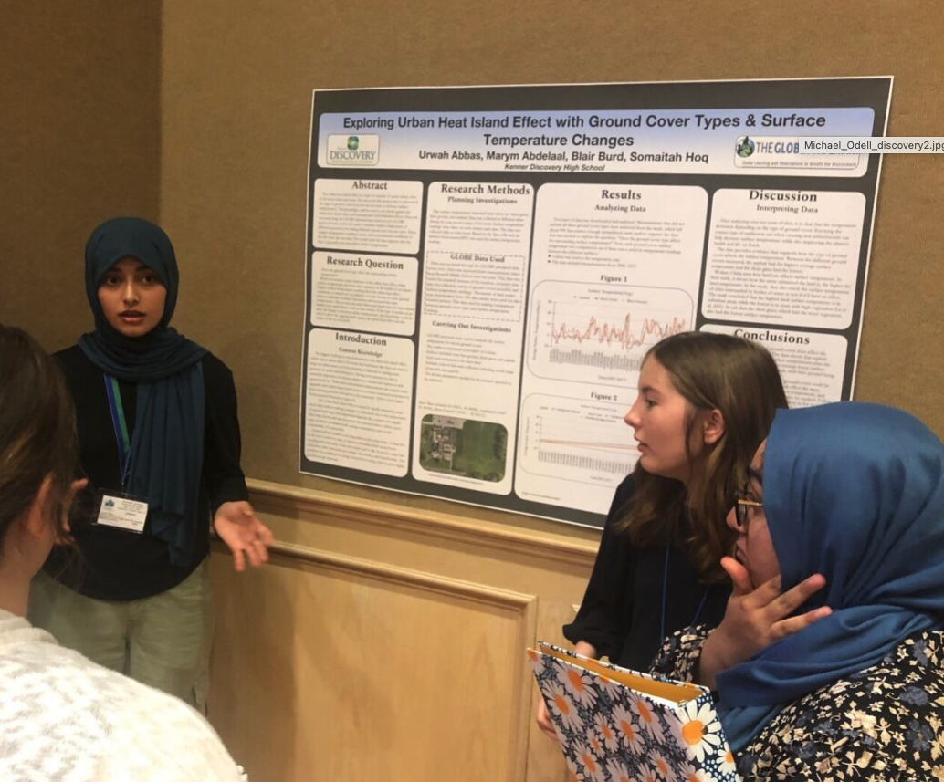 three students present at poster at the SRS
