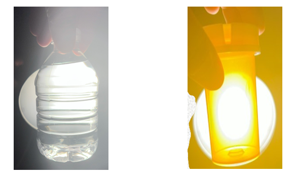 A hand holding a clear plastic bottle filled with water, letting most light pass through it. Next to that there is a hand holding an empty medication container of amber color, a lot of light passes through.