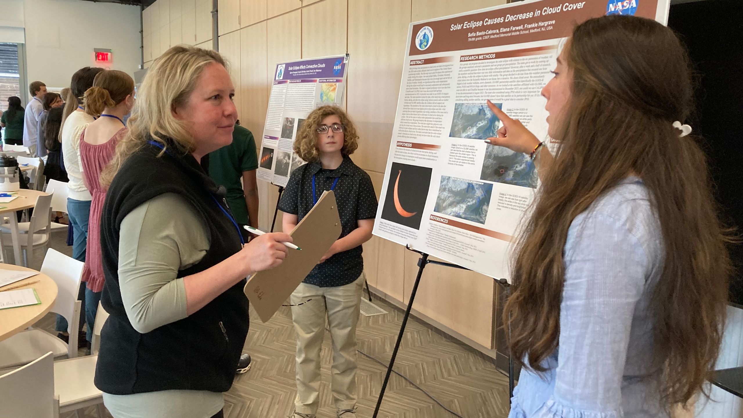 a STEM professional speaks with students about their research