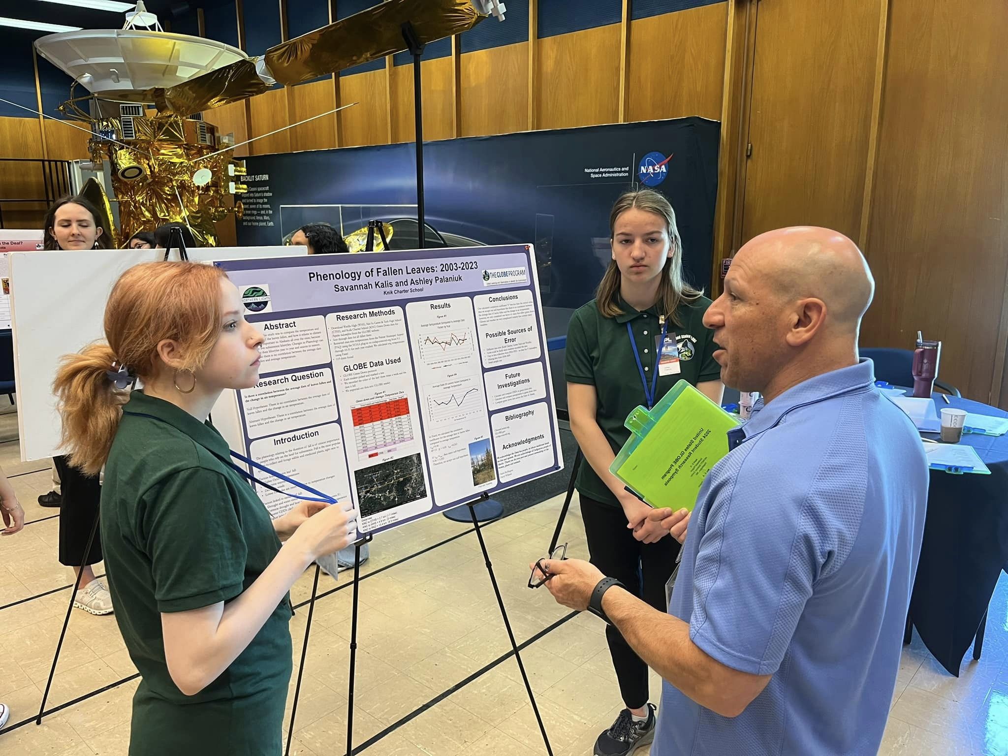 Two students talk to a STEM professional at the SRS