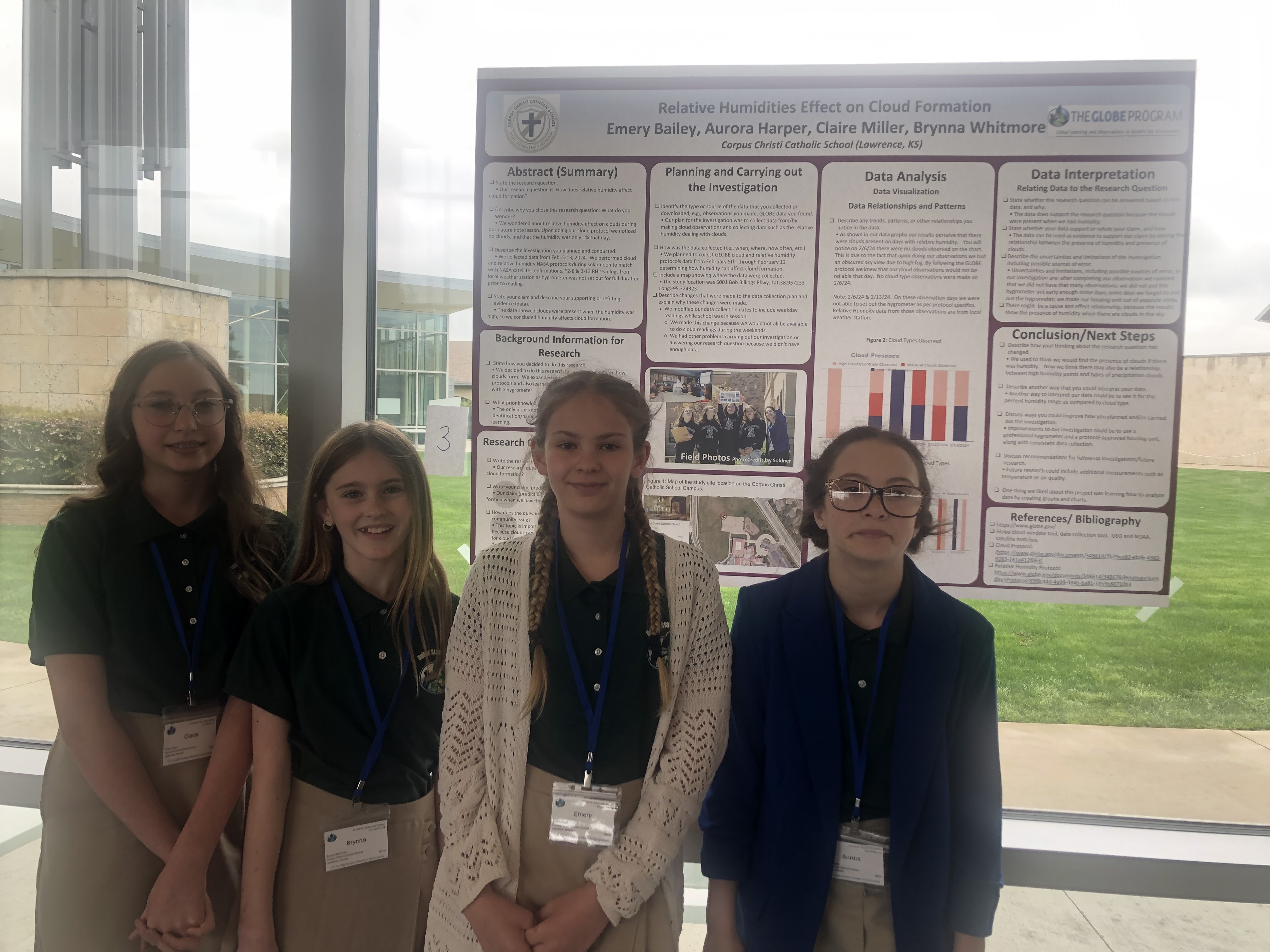 Four students stand in front of their research poster